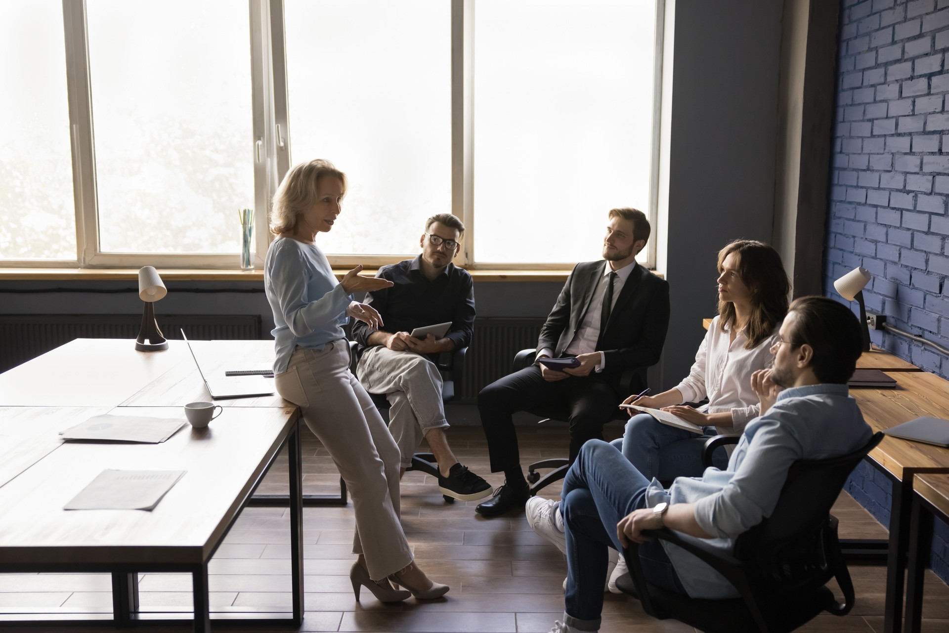 Serious confident female business mentor training office group